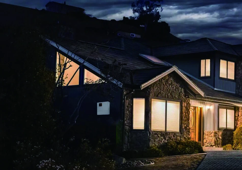 Illuminated residential home at night illustrating a home backup power application